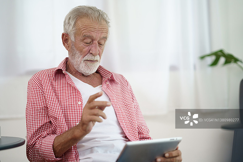 老年人在家使用平板电脑在线交流图片素材