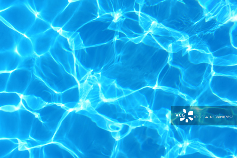 泳池中美丽的阳光倒影：夏季蓝色水波背景图片素材
