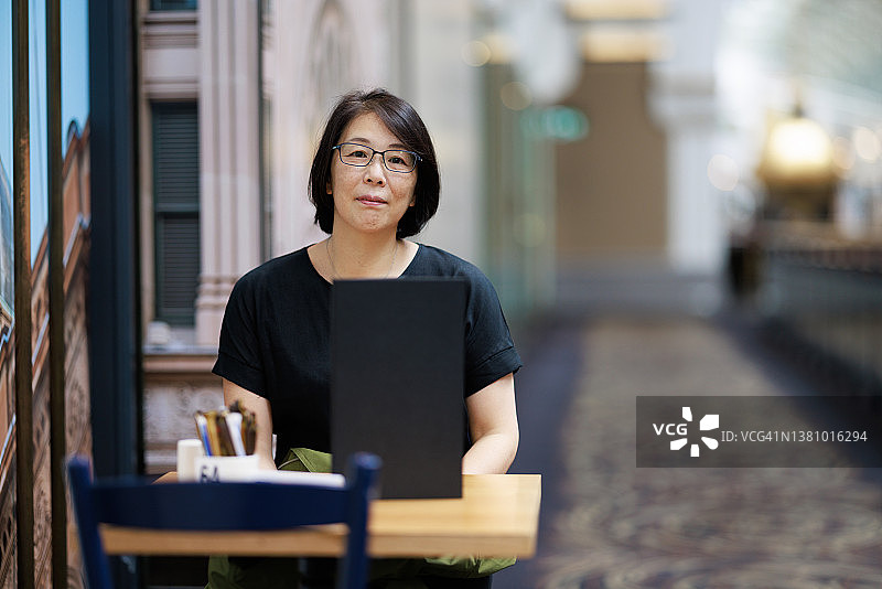 笑容满面的女人坐在桌子旁图片素材