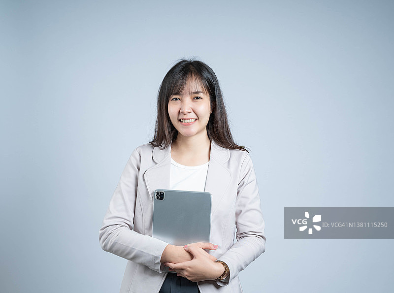 快乐优雅的职业女商人手持平板电脑看向镜头图片素材