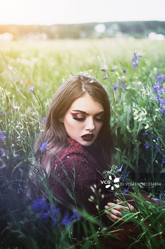 蓝色花丛中的年轻女子图片素材