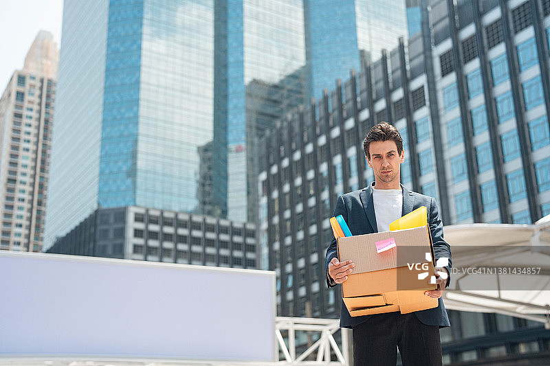 被解雇的商人抱着个人物品离开办公室图片素材