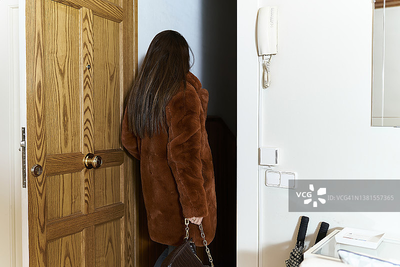 身穿正装的女子拎着手提包出门图片素材