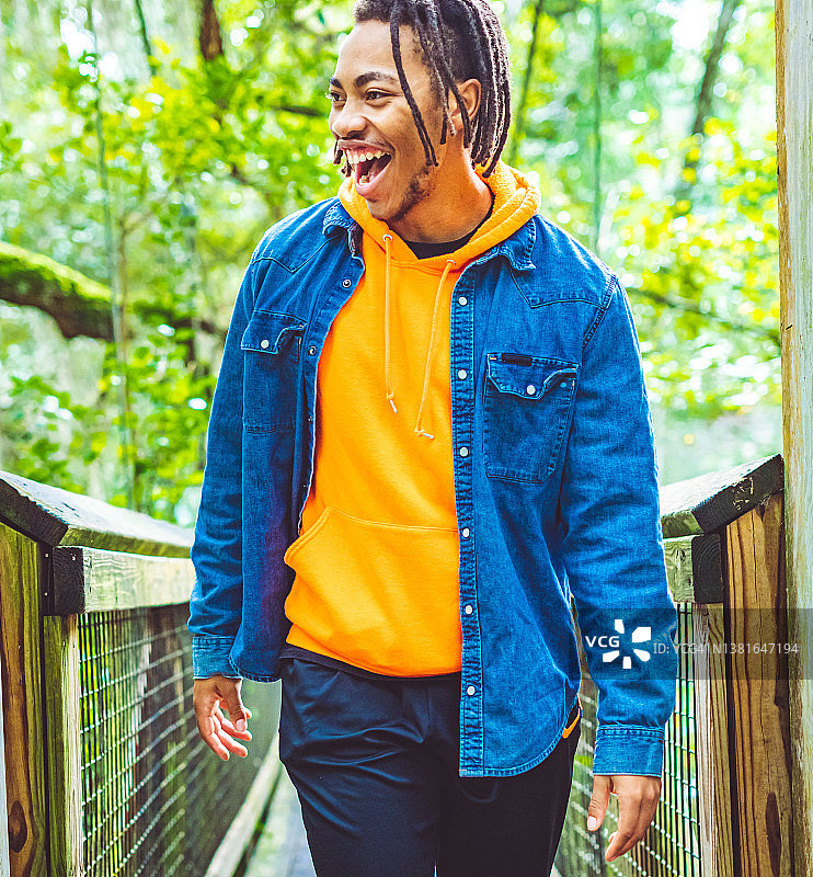 在热带雨林风景桥上摆姿势的快乐年轻黑人男子异国旅行冒险图片素材