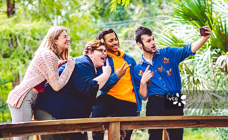 一群年轻的混血朋友用手机制作视频或自拍，用于内容创作或社交媒体图片素材