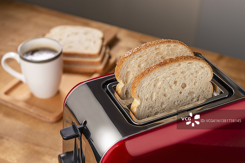 厨房桌子上的红色烤面包机和咖啡杯图片素材