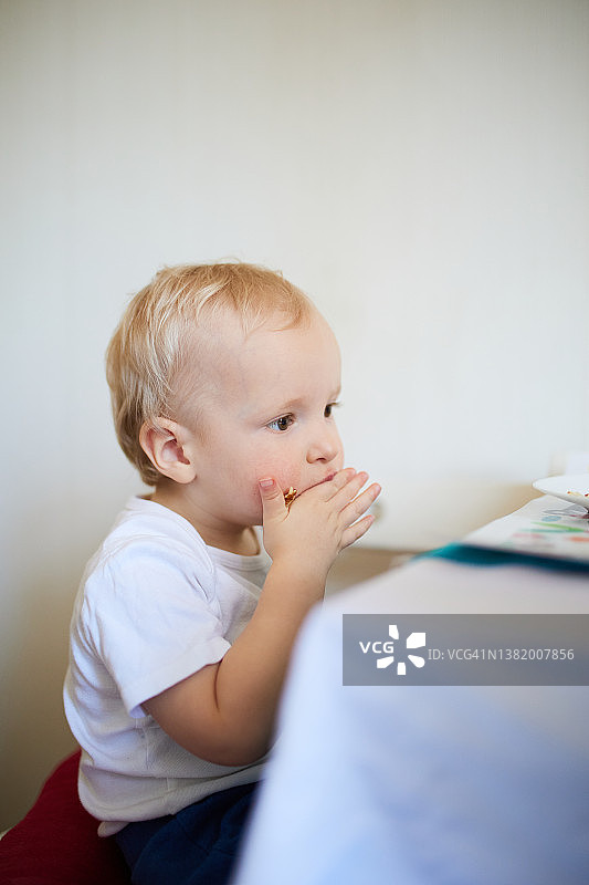 一岁男孩用手吃薄煎饼图片素材