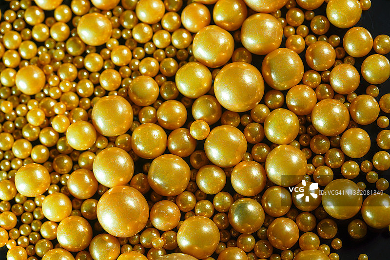 黑色背景中不同大小的金色圆球漂浮图片素材