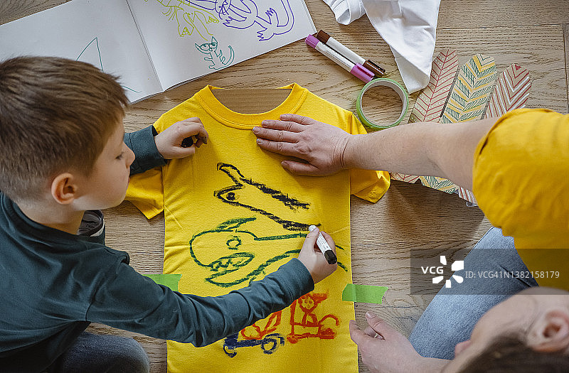 幼童在家在衬衫上绘画图片素材