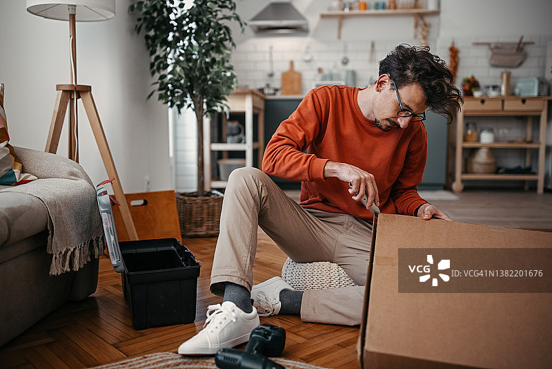 在家拆箱子的年轻男人图片素材