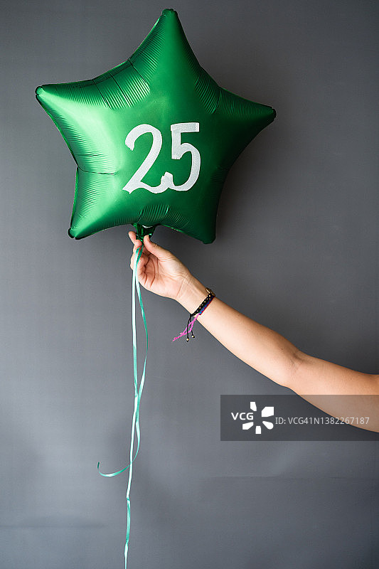 年轻女子手持25岁生日气球图片素材
