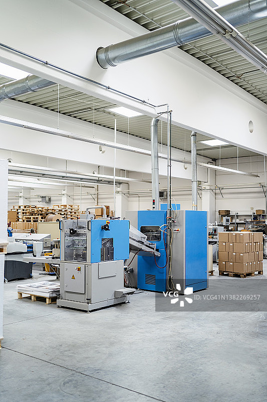 工厂中由机器排列的纸板箱图片素材
