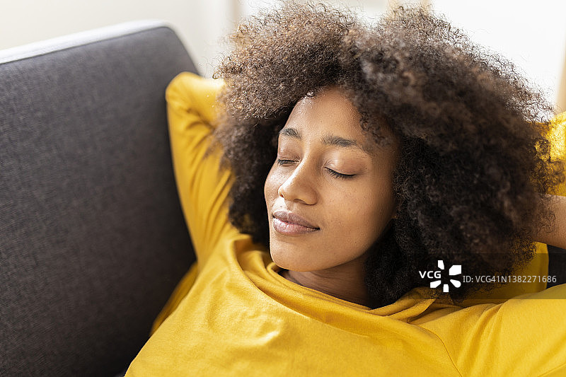 年轻女子闭着眼睛在家放松图片素材