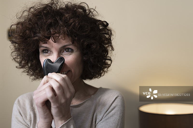 在家做刮痧的微笑中年妇女图片素材