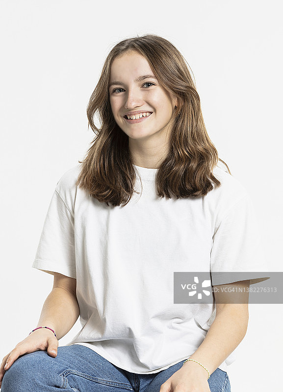 棕色头发的女孩在白色背景的影棚里图片素材