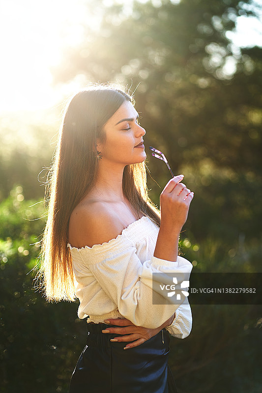 阳光下大自然中放松的年轻女人图片素材