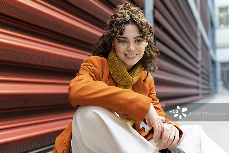 微笑的女人坐在人行道上图片素材