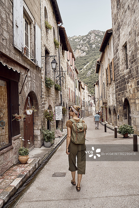 背着背包的女人在维尔弗朗什德孔夫伦镇散步图片素材