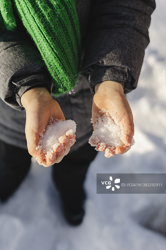 男孩在冬天拿着雪图片素材