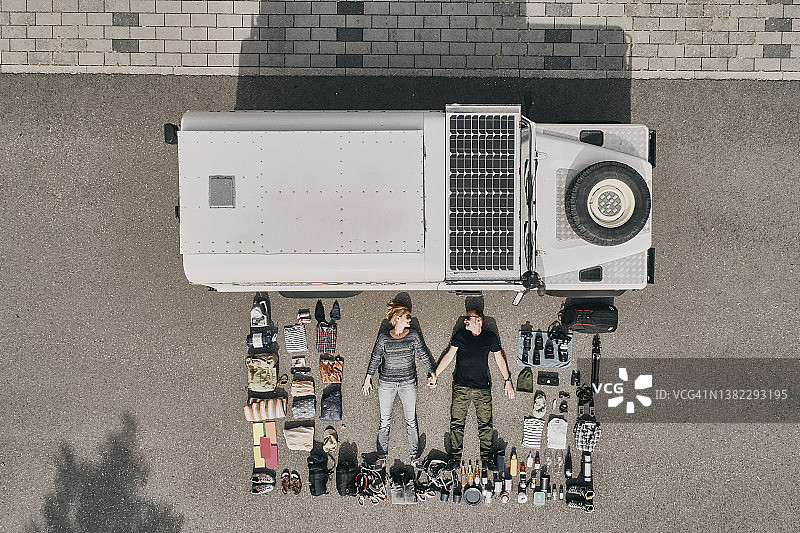 情侣躺在越野车旁边的路上图片素材