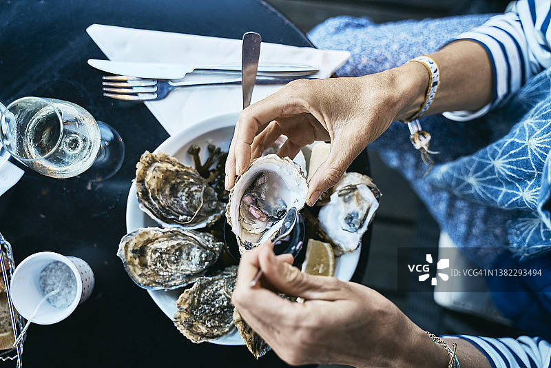 女人在餐桌吃生蚝图片素材