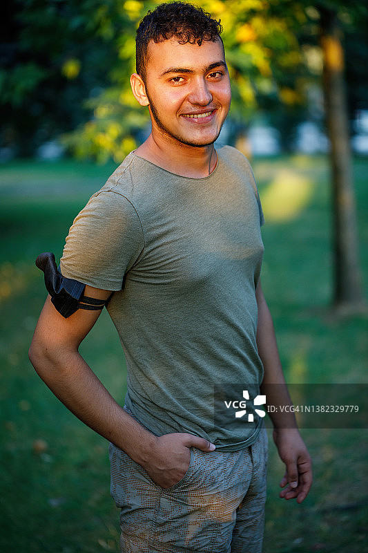 手臂上戴着口罩的年轻男人图片素材