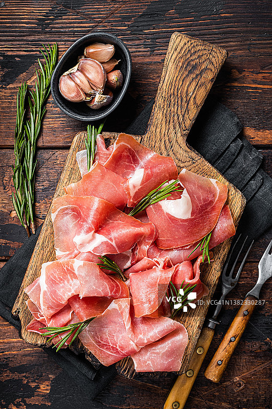 木板上的西班牙火腿或意大利熏火腿切片图片素材