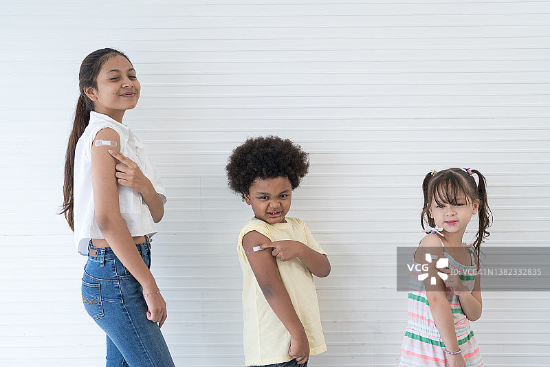 接种疫苗后，小学生们看着镜头微笑图片素材