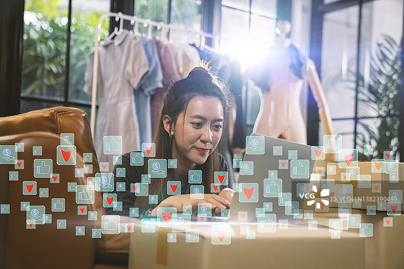 亚洲女性在家中通过社交网络直播销售服装图片素材