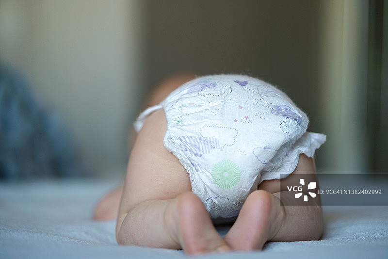 在床上穿着尿布的婴儿图片素材