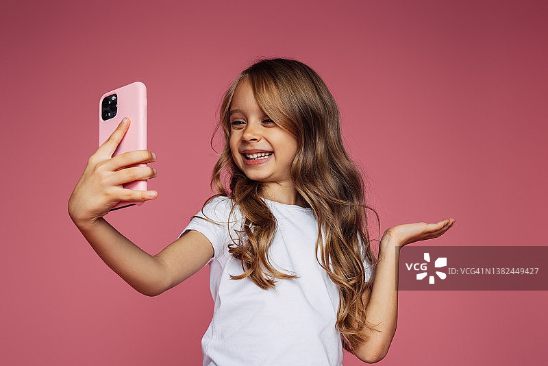 使用手机的可爱蓝眼睛女孩图片素材