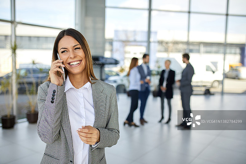 快乐的年轻女商人正在用智能手机交谈图片素材