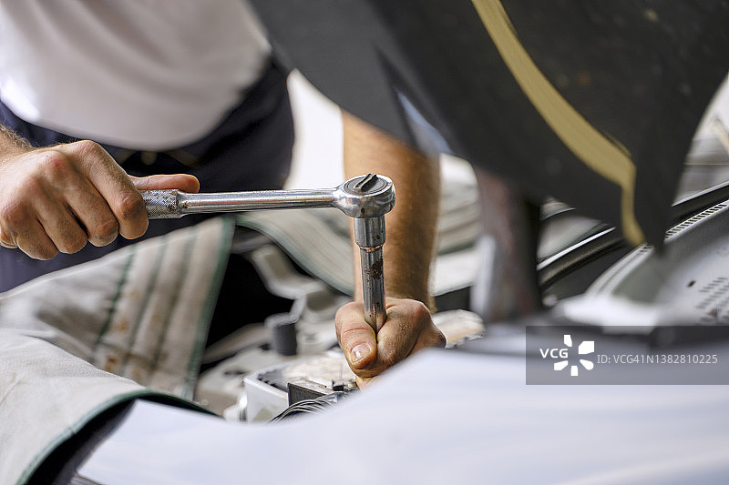 技术员在汽车维修站检查发动机图片素材