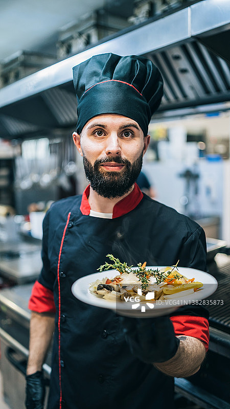 男厨师在餐厅厨房展示菜肴图片素材