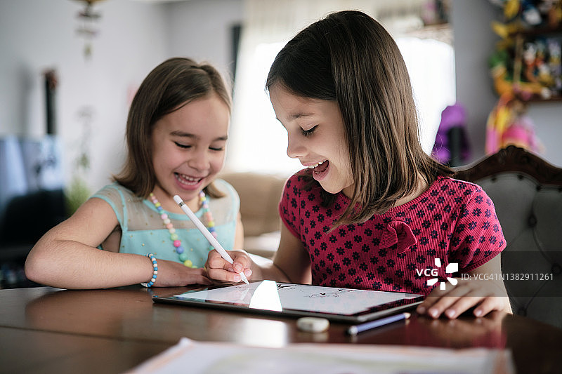 孩子们在家使用数位笔在数位平板电脑上绘画图片素材
