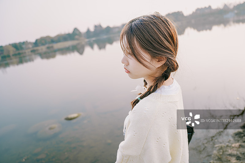 黄昏时湖边悲伤的亚洲美女图片素材