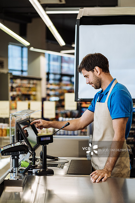 超市员工在收银台工作图片素材