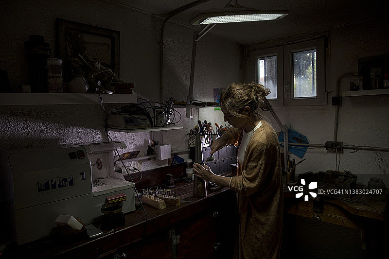 在工作室工作的工匠珠宝女商人图片素材