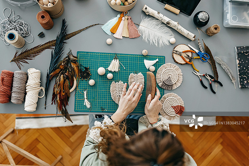 在工作室制作手工珠宝的年轻女性图片素材