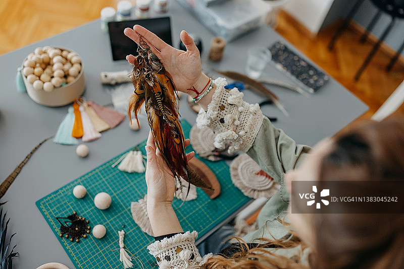 在工作室制作手工珠宝的年轻女性图片素材