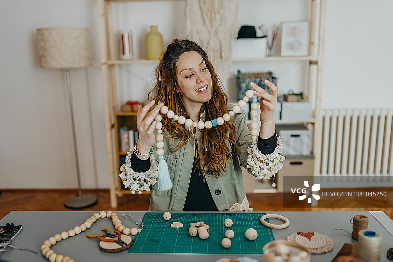 在工作室制作手工珠宝的年轻女性图片素材