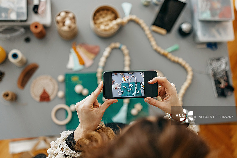 在工作室制作手工珠宝的年轻女性图片素材