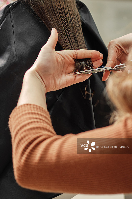 理发师用剪刀剪发，穿着橙色衣服图片素材