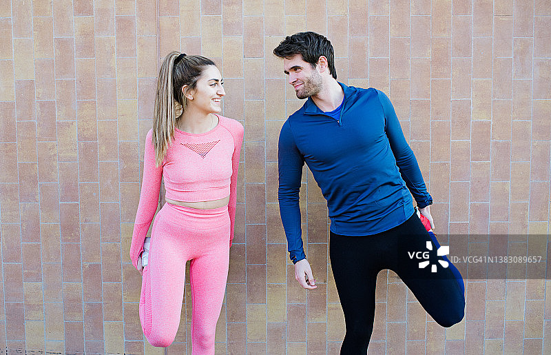 两名年轻人正在热身腿部并锻炼，一男一女正在做腿部伸展运动图片素材