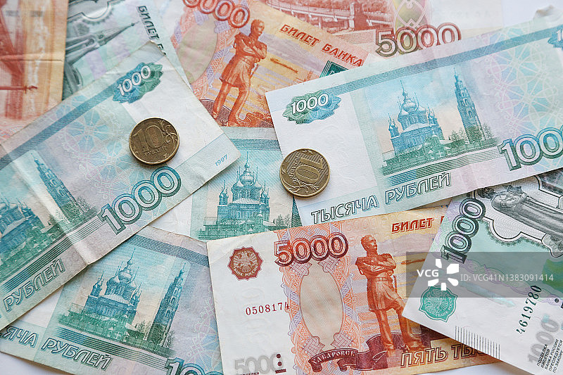 模糊的俄罗斯纸币背景下的十枚卢布硬币图片素材
