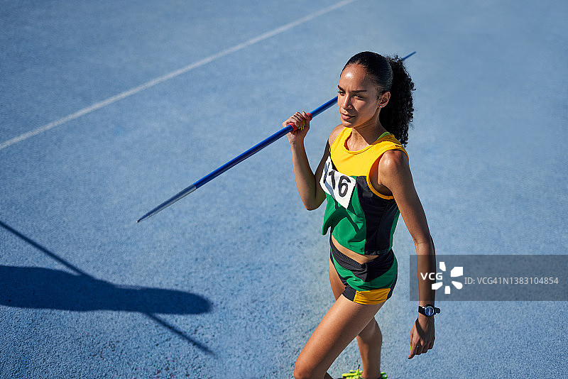 田径女运动员在跑道上准备掷标枪图片素材