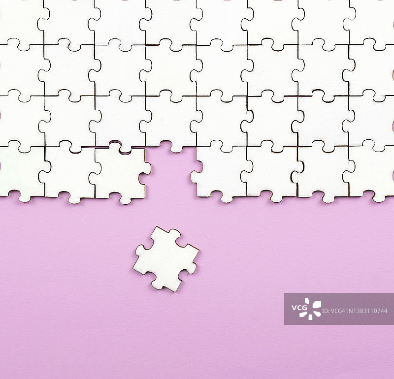 粉色背景上的白色拼图图片素材