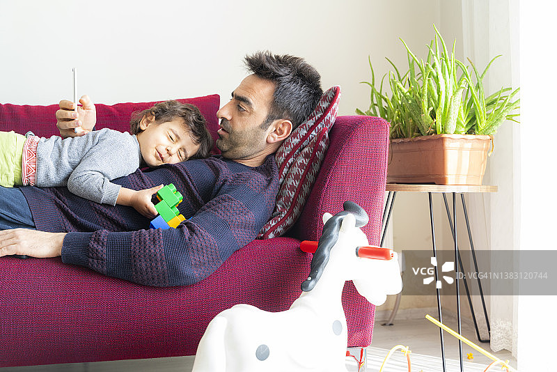 在沙发上睡觉，睡在父亲胸前的孩子图片素材