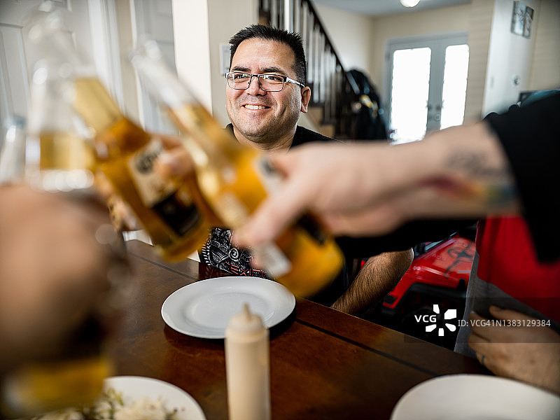 年长的西班牙裔男人与朋友在桌旁图片素材