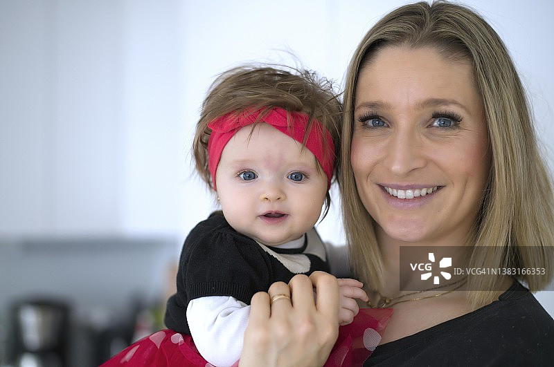 母亲抱着6个月大的女儿在德国斯图加特欢笑图片素材